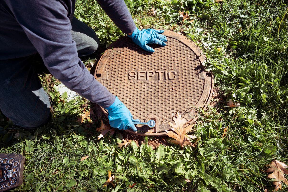 Technician opening a septic tank access lid